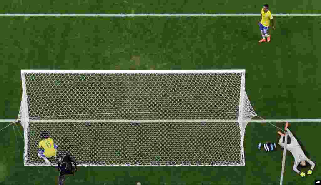 Brazil goalkeeper Julio Cesar lies on the pitch as Brazil's Marcelo picks up the ball from the net after Germany's Andre Schuerrle scored at the Mineirao Stadium in Belo Horizonte, Brazil, July 8, 2014. 