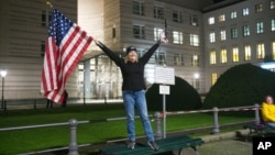 Marrianne Hoenow iz američke države Connecticut proslavlja pobjedu Bidena i Harris ispred američke ambasade u Berlinu, pored Brandenburške kapije, 7. novembra 2020. (Foto: AP)