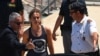 Carola Rackete, the 31-year-old Sea-Watch 3 captain, disembarks from a Finance police boat and is escorted to a car, in Porto Empedocle, Italy, July 1, 2019. 