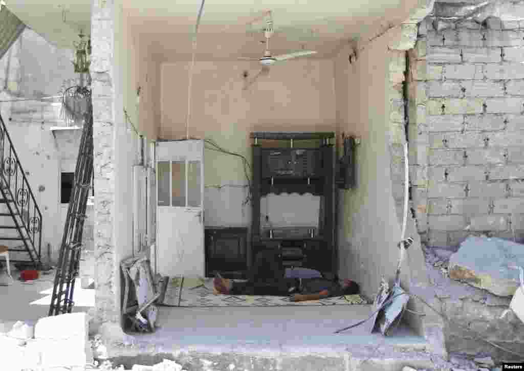 Men sleep inside a house damaged after what activists said was an air raid by forces loyal to Syria's President Bashar al-Assad in Azaz, near Aleppo, August 6, 2013. 