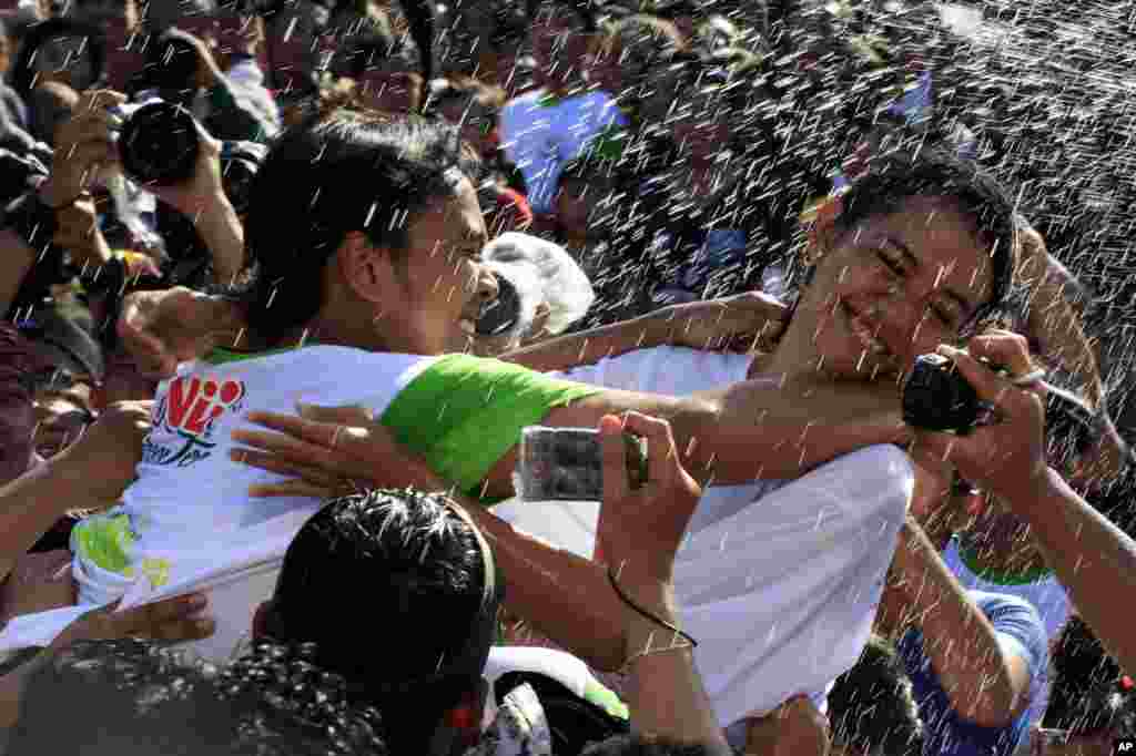 Seorang gadis Bali (kanan) berusaha menghindar dari ciuman seorang pria saat festival keagamaan &quot;Omed Omedan&quot; di Bali, Indonesia.
