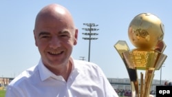 Le président de la FIFA, Gianni Infantino, tient un trophée à Doha, Qatar, 22 avril 2016. epa/ STRINGER